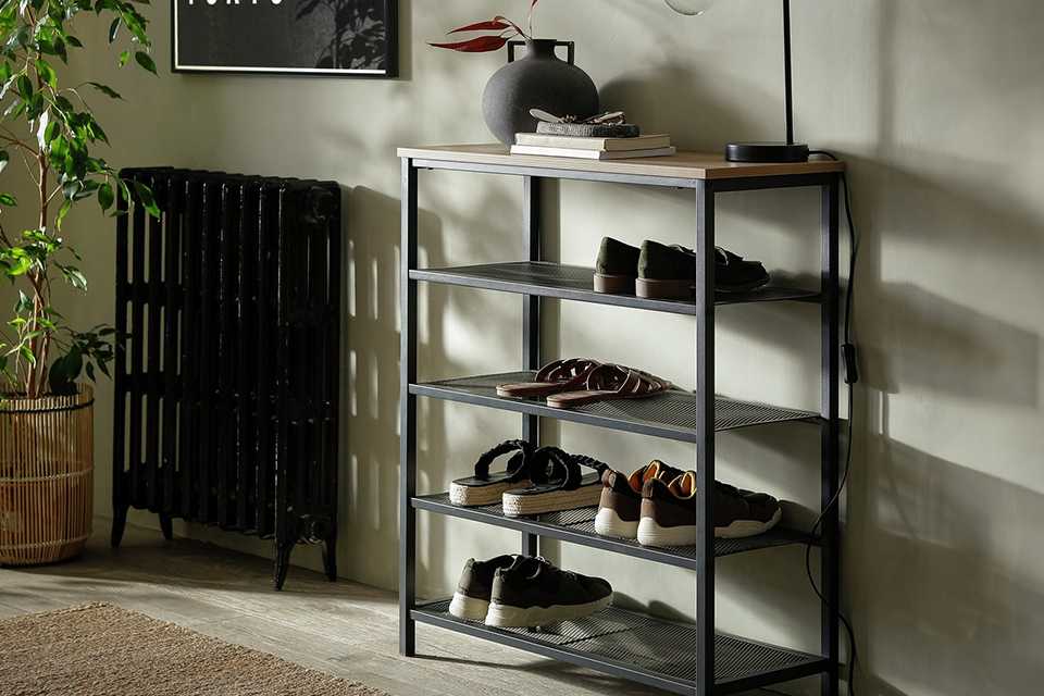 Habitat Loft Living 5 Shelf Shoe Storage Rack in black colour placed in a hallway with a vase, a table lamp, and books placed on it.