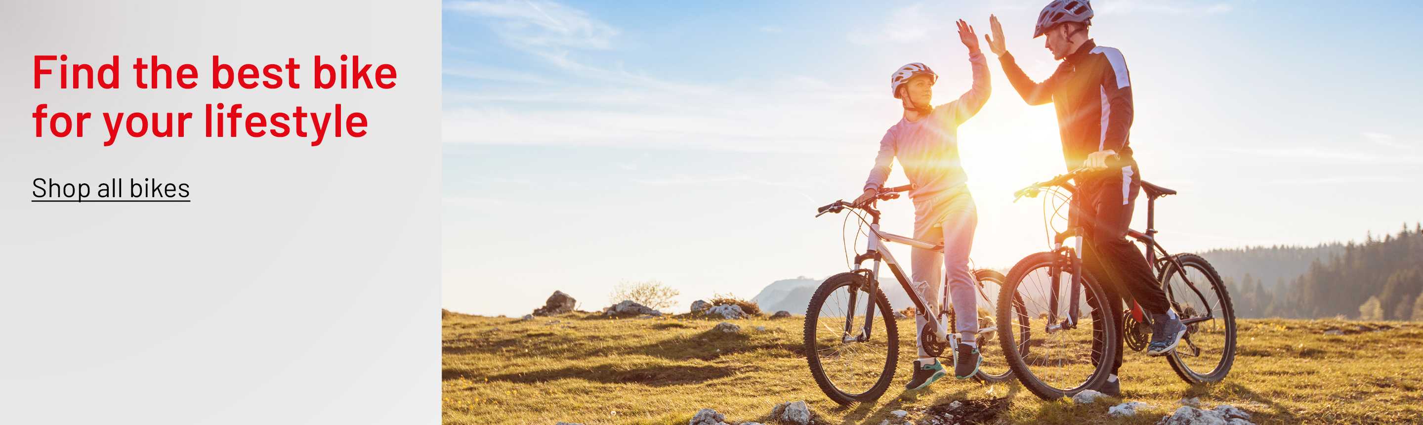 A happy couple giving each other a high five on a mountain on their bikes.