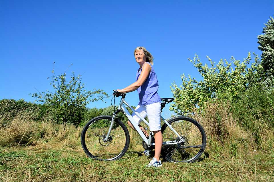 A woman on a hybrid bike on a mountain.