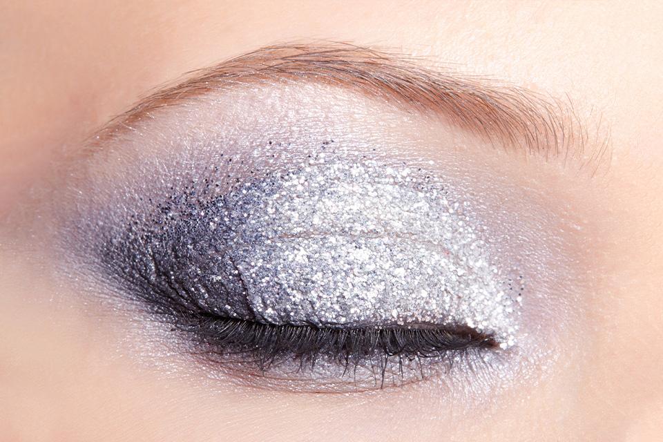 Eye with bold glitter smokey eye makeup.