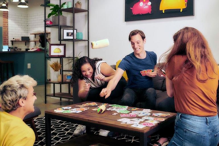 Four friends play a game in their living room.