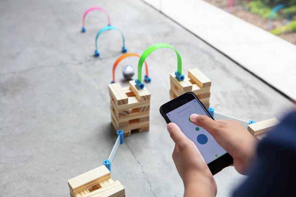 A Sphero ball navigates its way through some wooden blocks and obstacles.