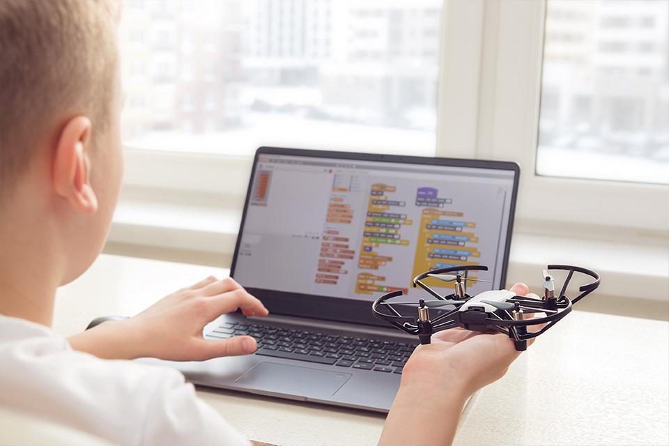 A boy programs a drone using Scratch programming software.