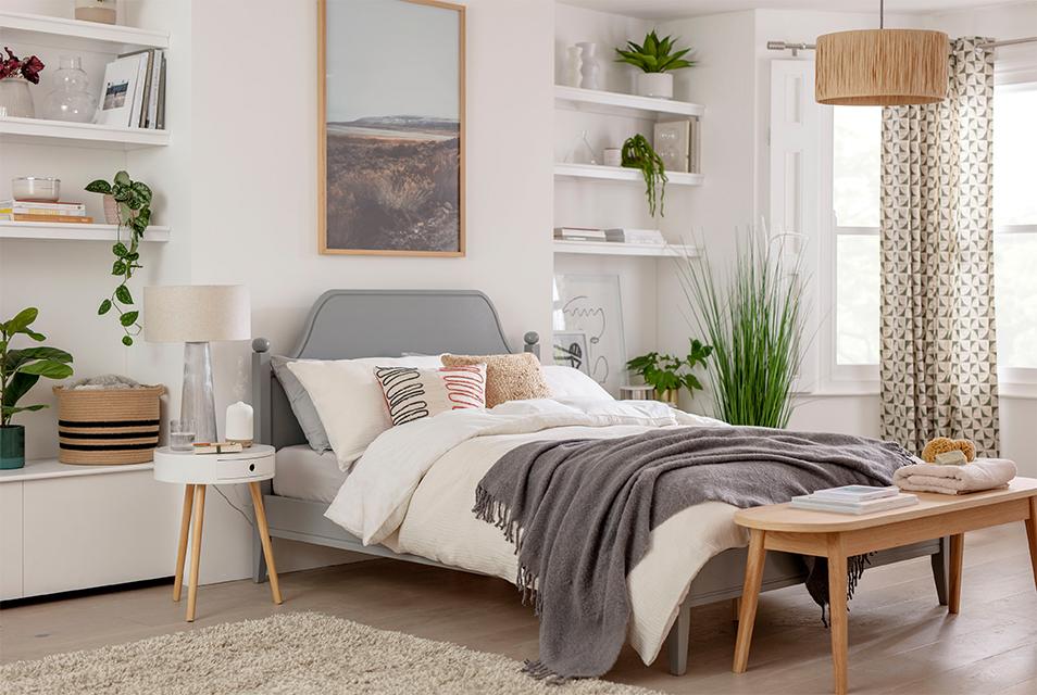 Image of a neutral coloured bedroom with a bed in the centre.