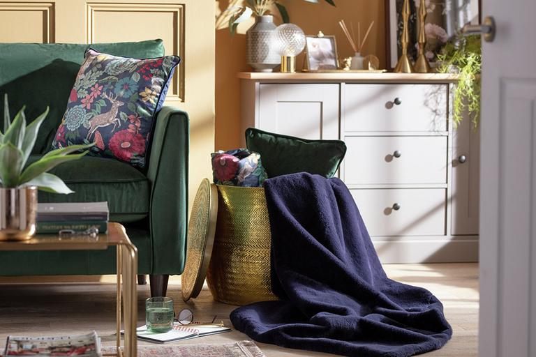 Lounge scene with green sofa and navy throw.