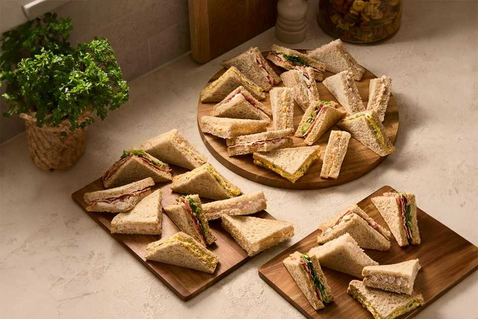 A wooden serving board with Sainsbury's large classic sandwiches.