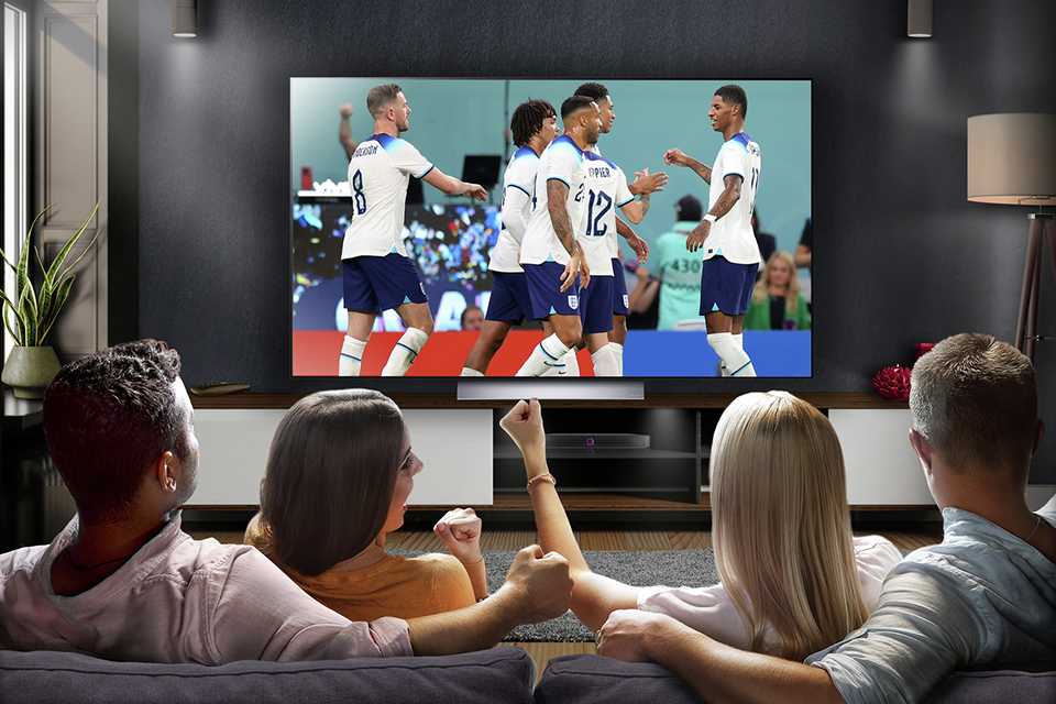 A group of friends watching sports on a TV.