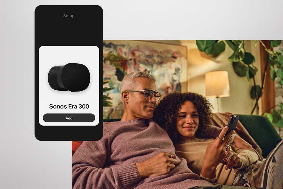 A couple relaxing on a couch while connecting to a Sonos device.
