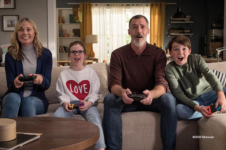 A family of four, playing the Nintendo Switch.