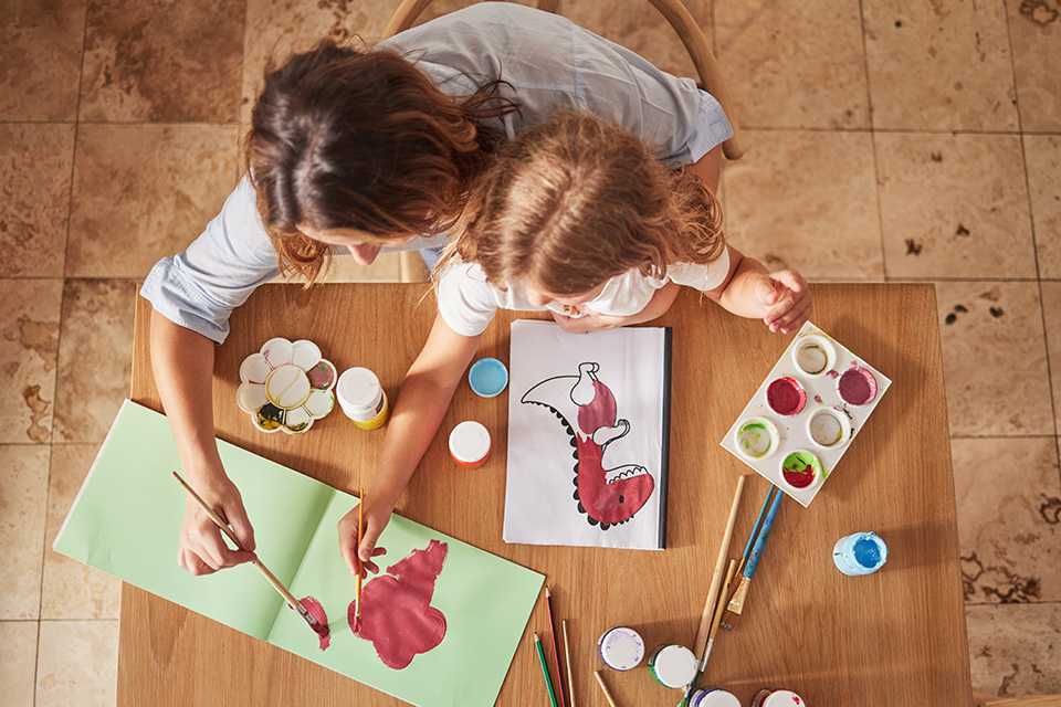A mother and a child painting to make a customised book cover.