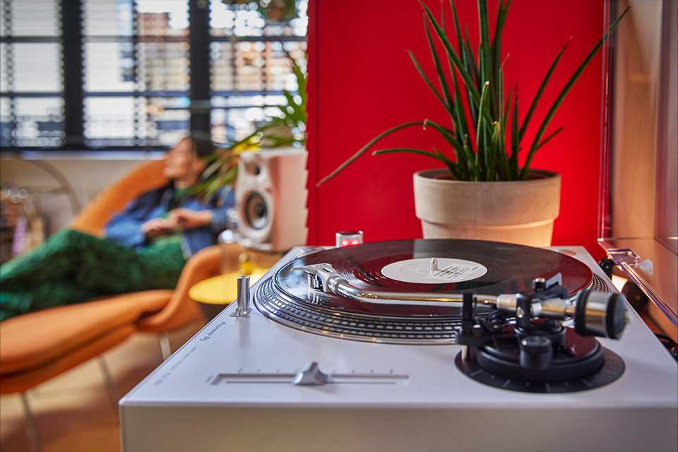 A Pioneer DJ turntable placed on a table of a living room.