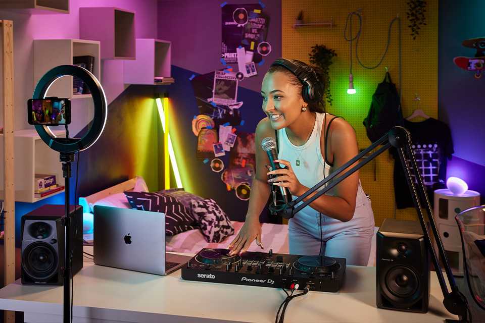 A young girl standing in front of a Pioneer DJ controller set.