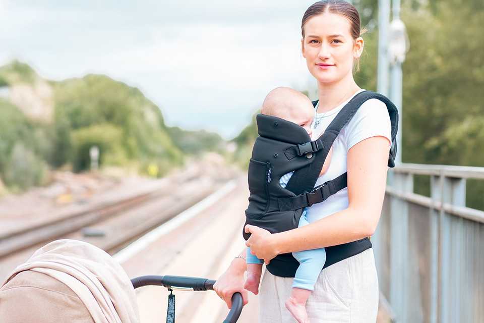 A mother carrying her baby in a Red Kite Ara Carrier.
