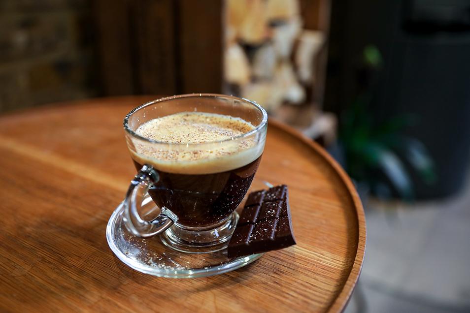 Small glass coffee cup and saucer with chocolate.
