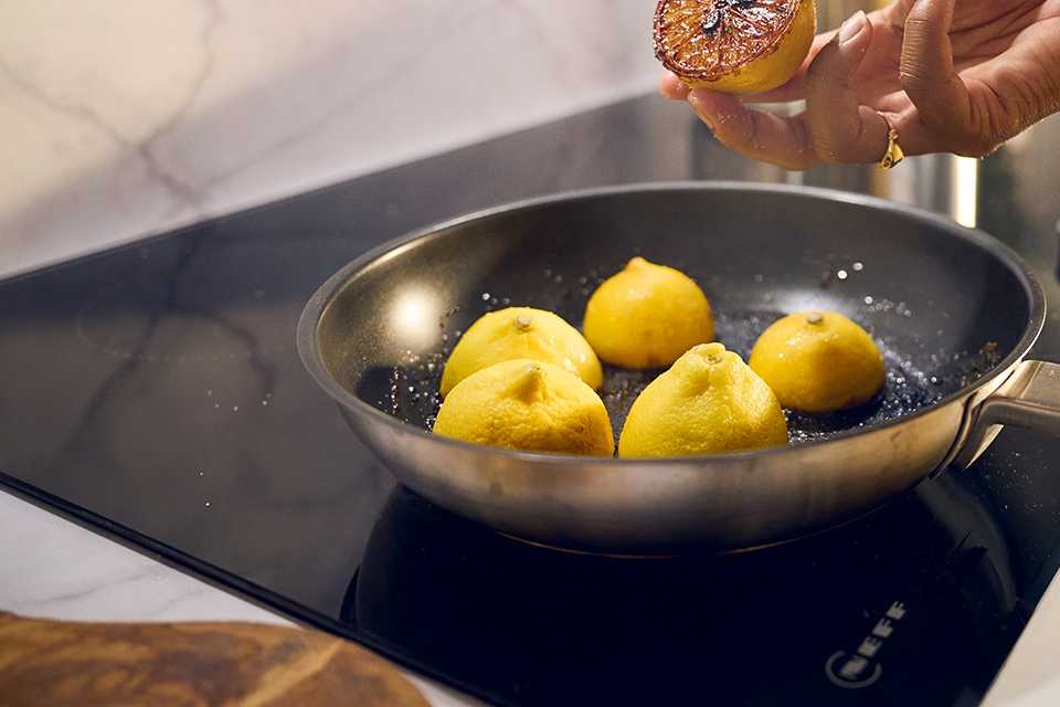 A NEFF hob with a pan with cooked potatoes placed in it.