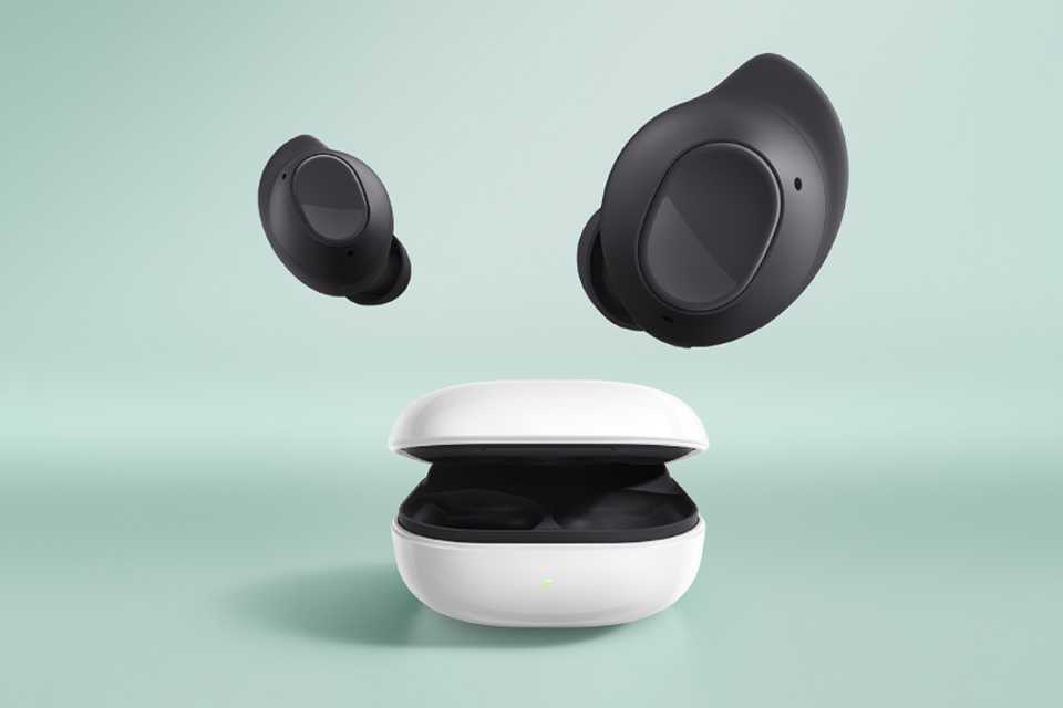 Samsung Galaxy Buds FE earbuds floating out of its charging case on mint green background.