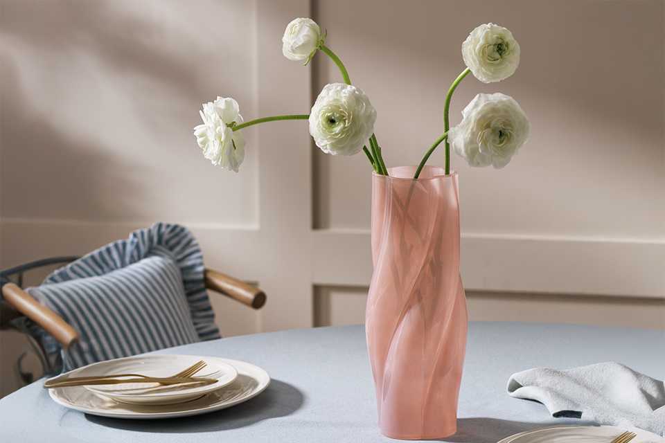 Pink spiral vase with flowers on dining room table, perfect for gifting your special someone.
