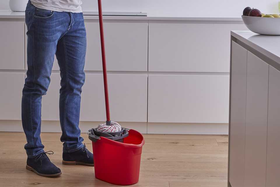 A man using a Vileda 10 Litre Microfibre Power Mop and Bucket Set.