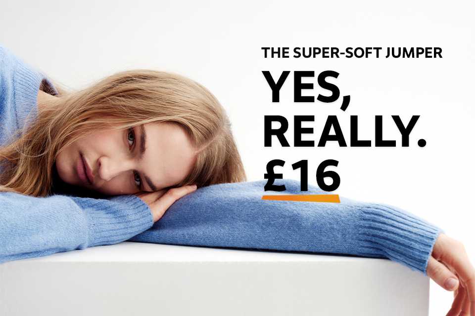 Woman wearing light blue jumper with a white shirt underneath.