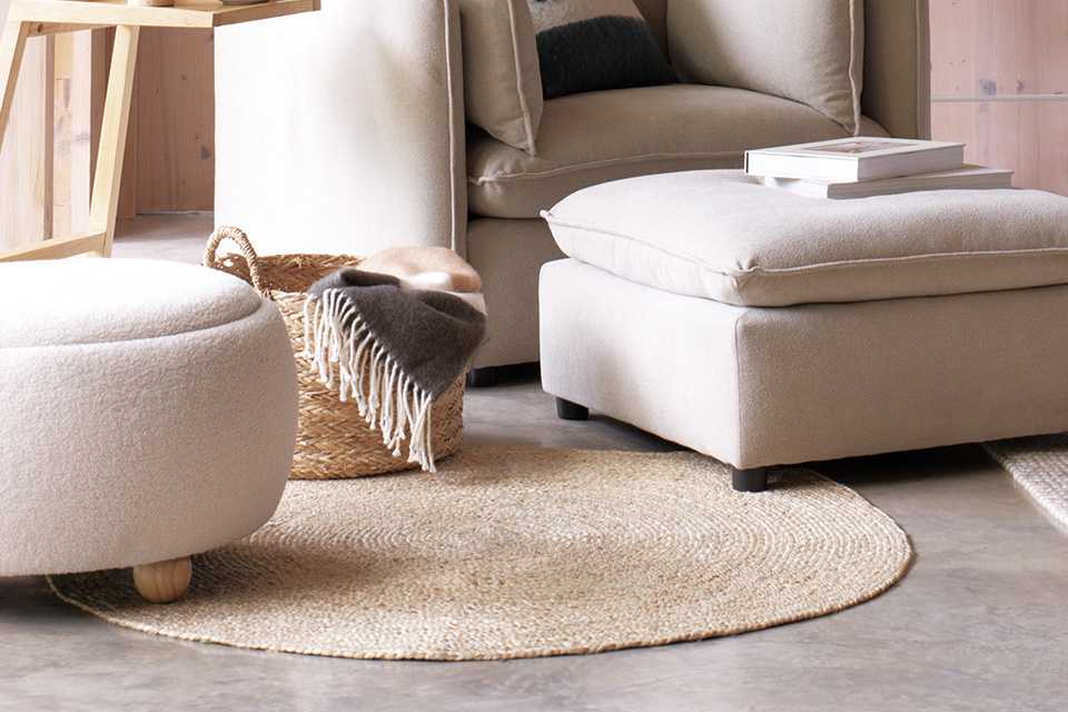 A cosy beige extra small rug under a sofa and coffee table.