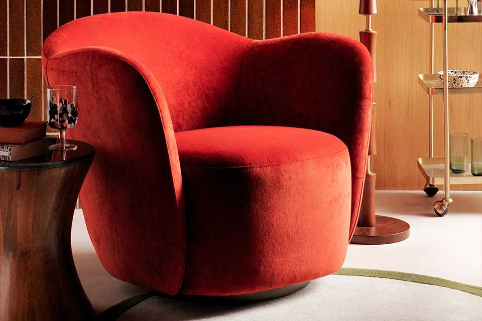 A living room with a sofa, coffee table, lamp, and round rug.