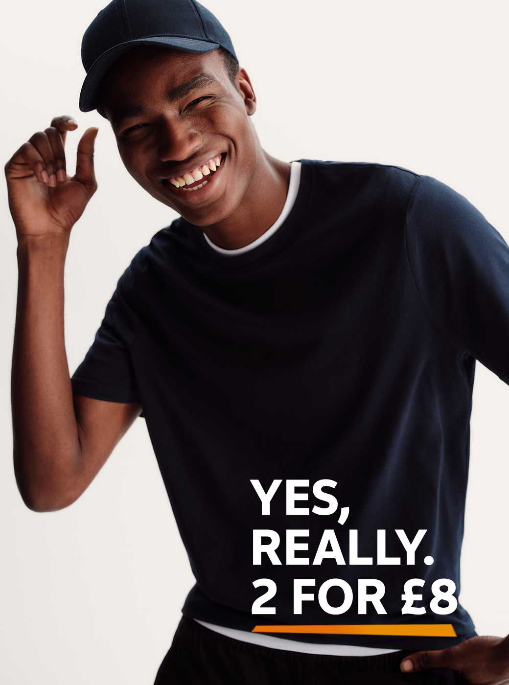 A man wearing a dark pure cotton t-shirt, wearing the same colour baseball cap.