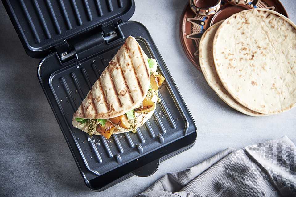 A George Foreman grill with a Morrocan flatbread grilling on it.