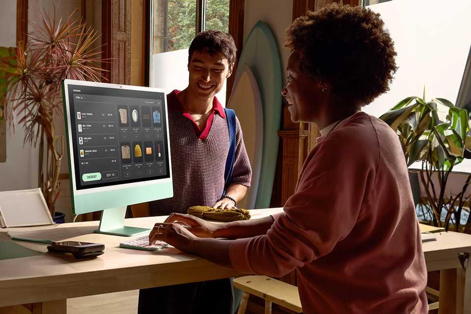 A woman using Apple iMac 2024 24in M4 8 Core 16GB 256GB in green colour.