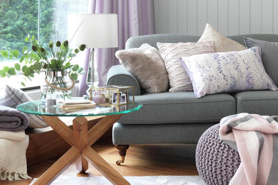 Lounge with grey sofa, glass coffee table and footstool.