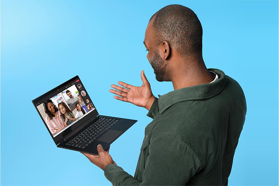 Young man holding a laptop while on a video call.