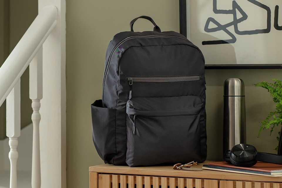 Argos Home Block Colour Grey Backpack placed on a wooden storage unit.