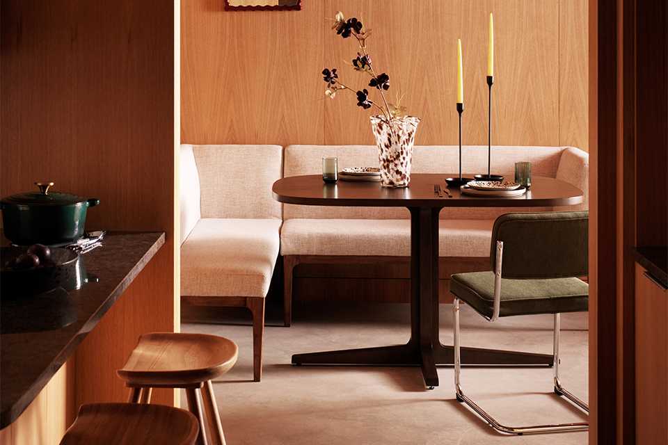 Two pillar candles on a table in a cosy room.