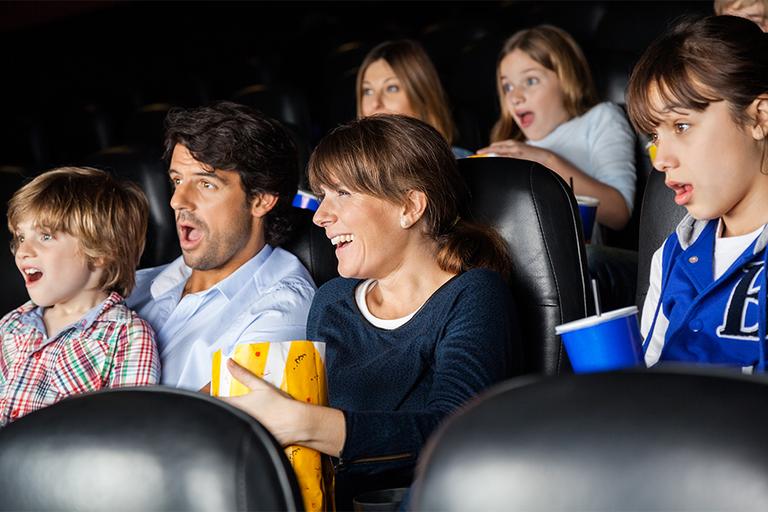 Family watching film in the cinema.