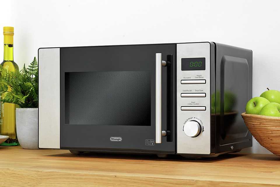 De'Longhi 800W Standard Microwave AM82 in stainless steel finish placed on a kitchen counter.
