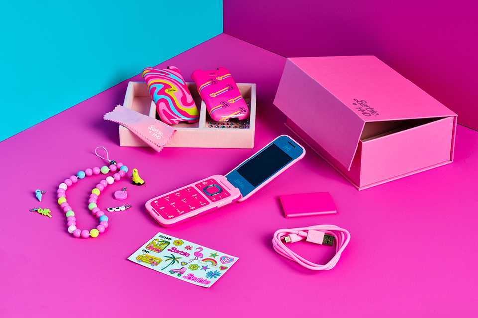 HMD Barbie™ phone with all other items in the box laid out on a pink background.