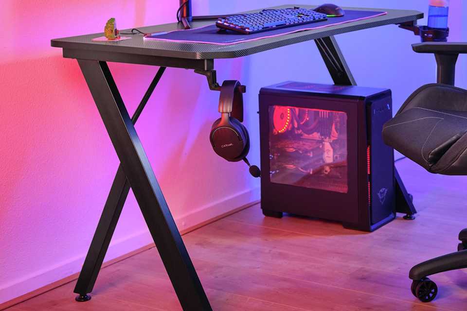 A minimal gaming setup with a desk, chair, one monitor and a CPU beneath.