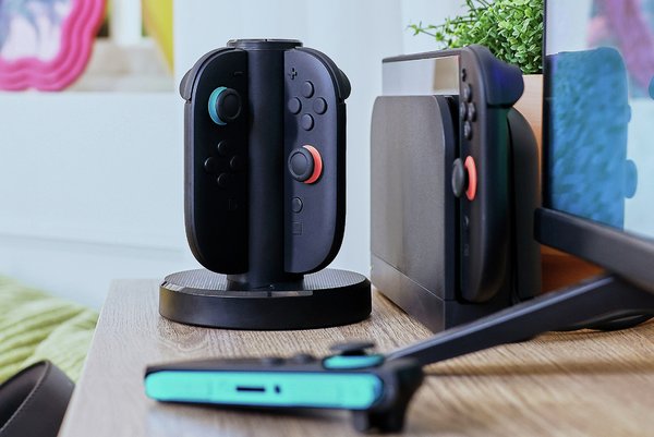 set up showing a switch 2 in a dock and charging stand for joy cons