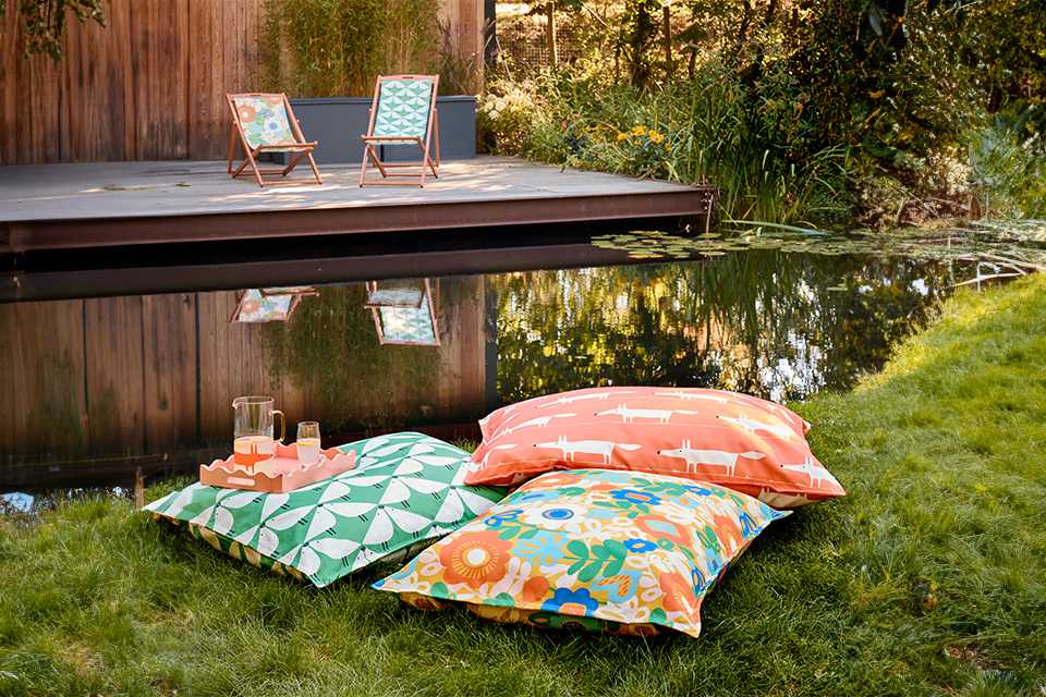 Habitat x Scion indoor outdoor bean bag cushions in Kukkia print placed outdoors on grass.