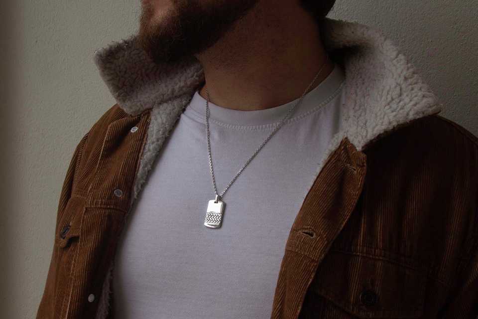 A close-up shot of a man wearing a Revere necklace.