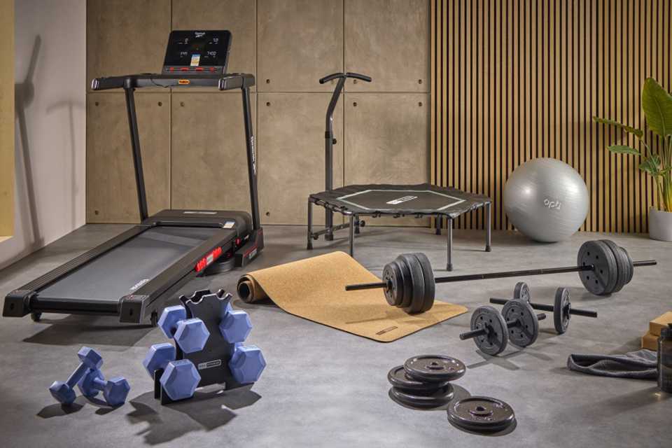 An assortment of home gym equipment including treadmill, weights, trampoline and gym ball.