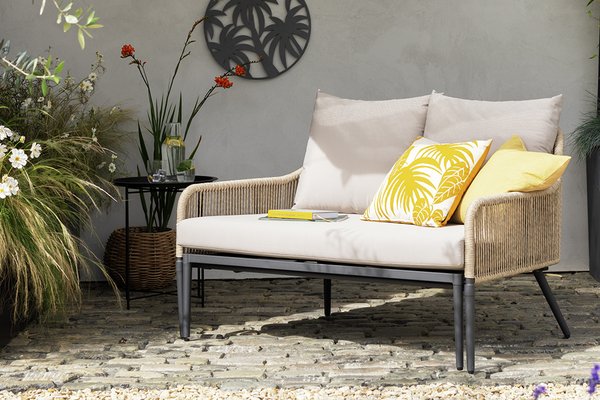 Sun lounger under umbrella in garden.