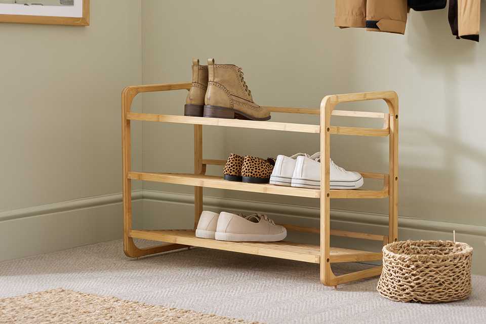Habitat Belem stackable shoe rack in natural finish with shoes and boots placed on it.