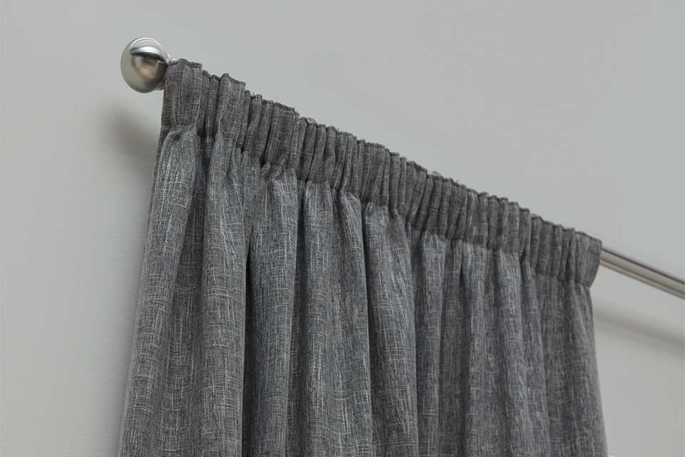 A Habitat blackout lined pencil pleat curtain in charcoal colour.