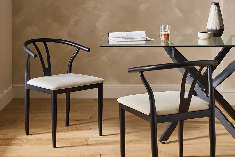 A glass dining table with black chairs.