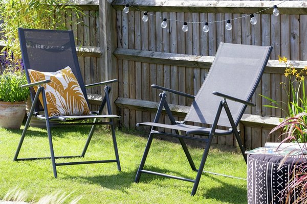 Two foldable garden chairs set in a garden scene