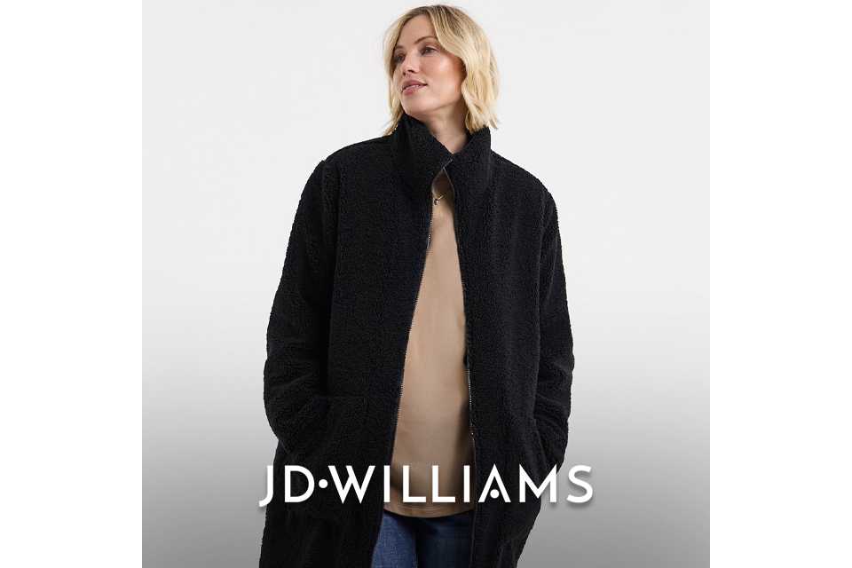 Black longline teddy coat layered over a beige top and blue jeans.