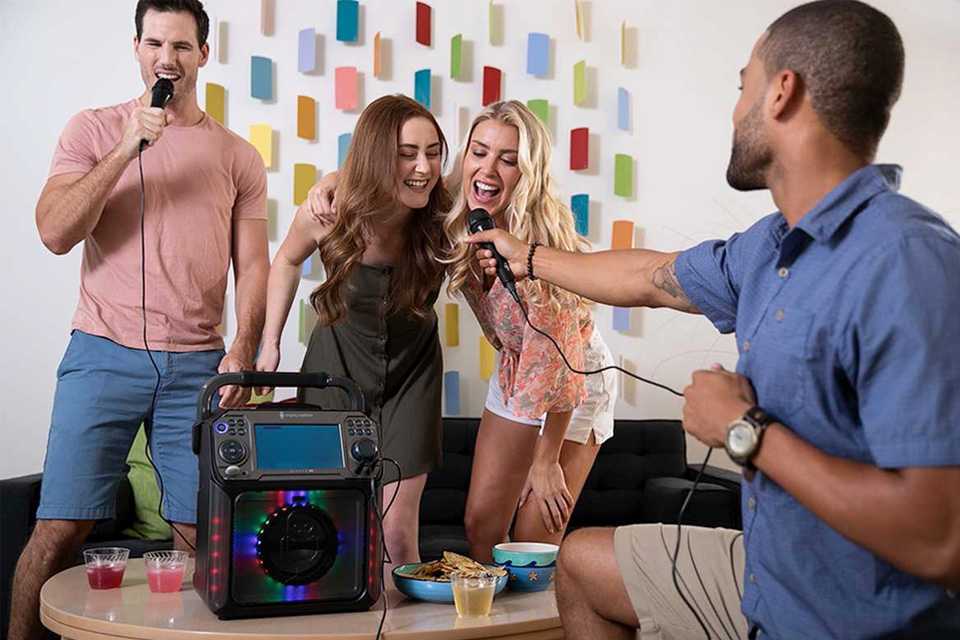 Friends using a karaoke machine to sing songs.