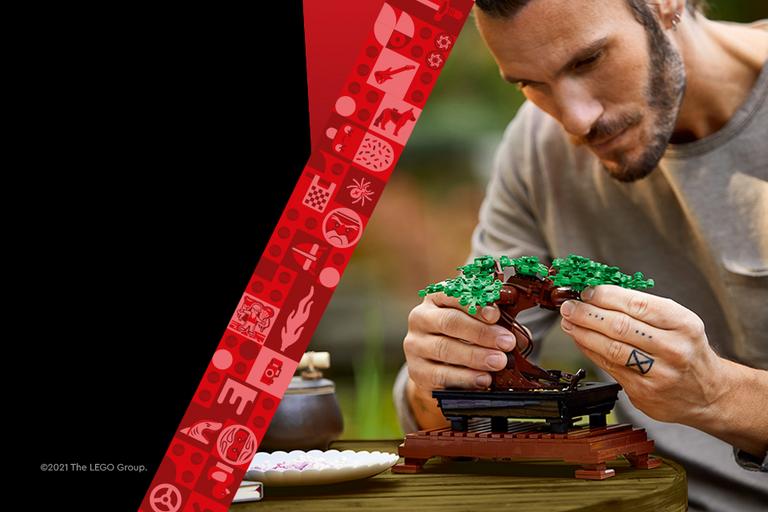 A man looks intently at a green Lego model Lamborghini racing car.