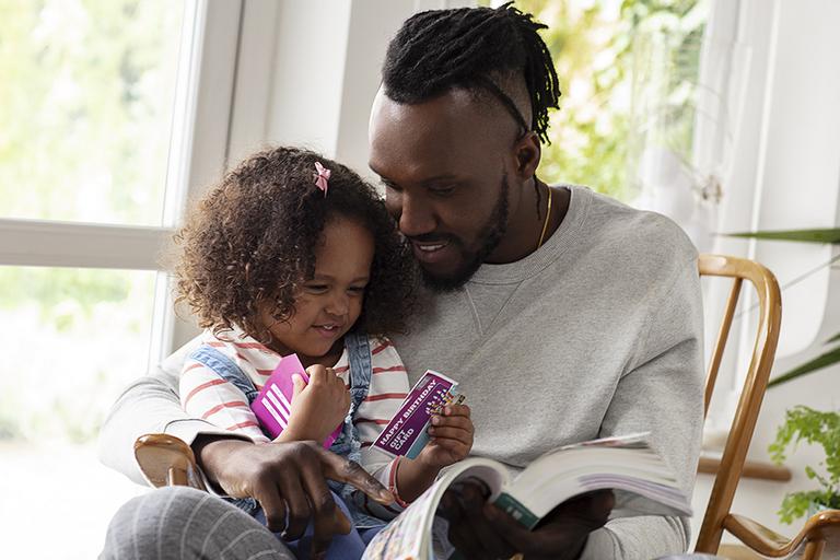 Man and child holding argos gift cards.