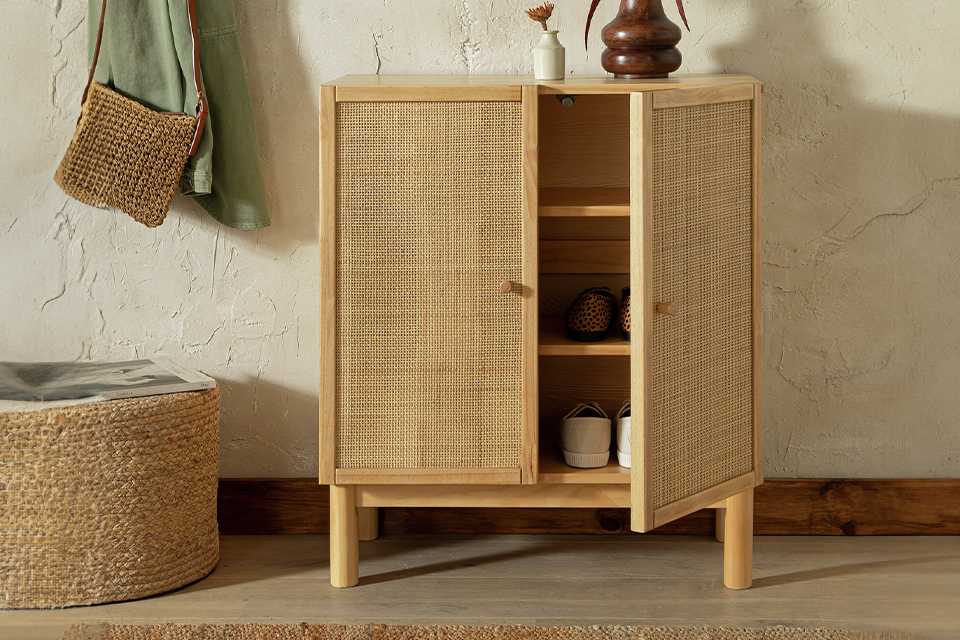 A Habitat Simone shoe cabinet placed in a hallway with a wooden vase on top of it.